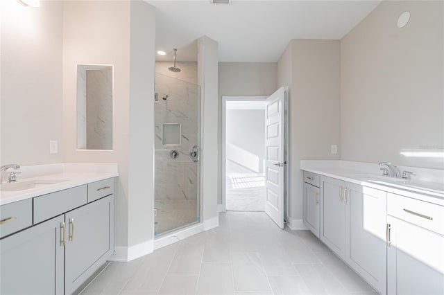 full bath featuring two vanities, a sink, and a marble finish shower