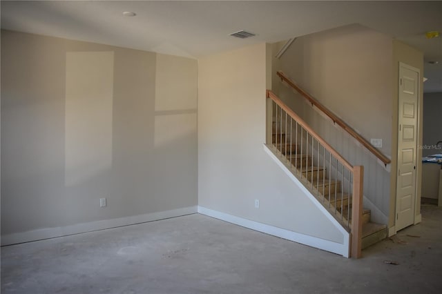 spare room with stairway, concrete floors, visible vents, and baseboards