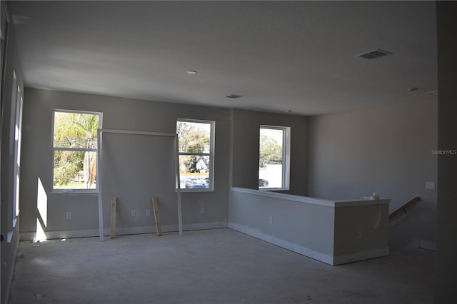 spare room with concrete floors, visible vents, and baseboards