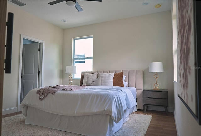 bedroom with dark hardwood / wood-style floors and ceiling fan