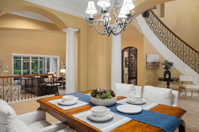 dining room with ornate columns, a towering ceiling, carpet, crown molding, and an inviting chandelier