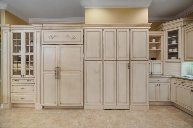 kitchen with light stone countertops, cream cabinetry, light tile floors, and ornamental molding