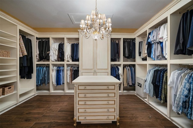 spacious closet with dark wood-type flooring and an inviting chandelier