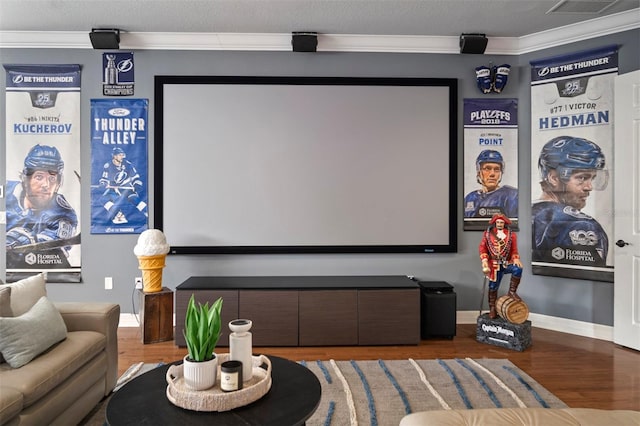 home theater with wood-type flooring, a textured ceiling, and crown molding