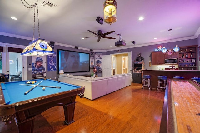 rec room featuring crown molding, light hardwood / wood-style flooring, pool table, and bar area