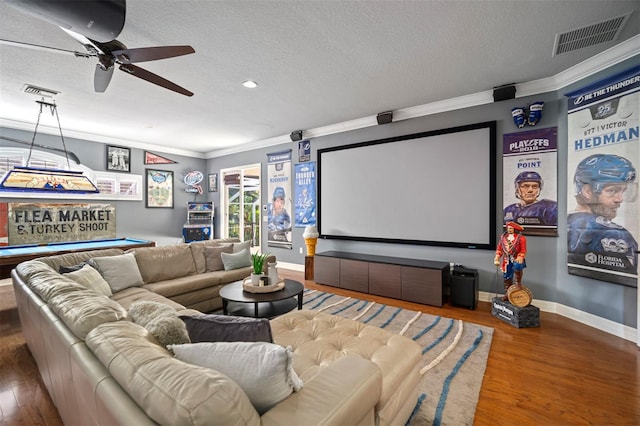 cinema featuring a textured ceiling, dark hardwood / wood-style floors, ornamental molding, and ceiling fan