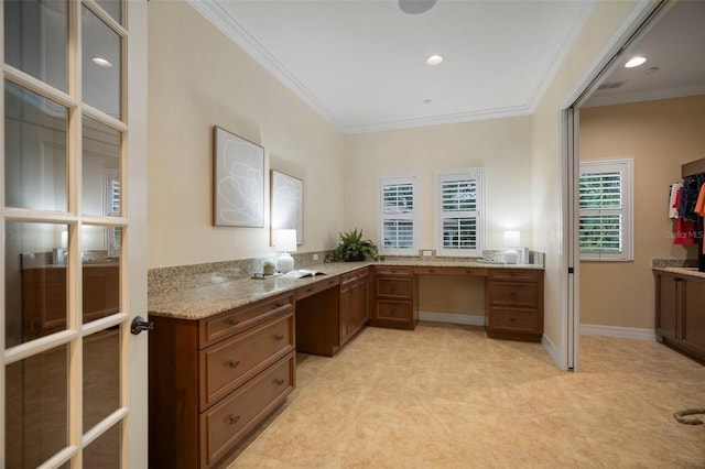 unfurnished office featuring ornamental molding and built in desk