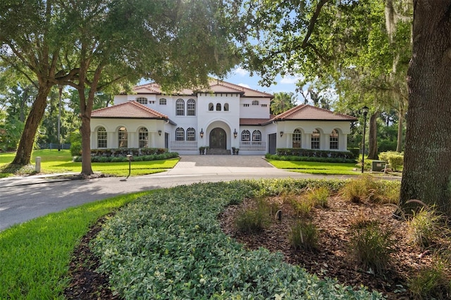 mediterranean / spanish-style home featuring a front yard