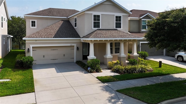 view of front facade featuring covered porch, a front yard, and a garage