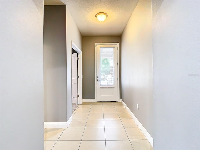 entryway with light tile patterned floors and a textured ceiling