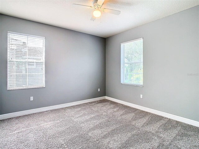 carpeted empty room featuring plenty of natural light and ceiling fan