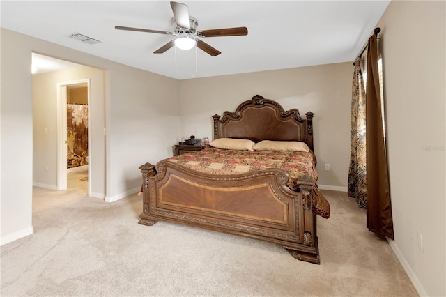 bedroom featuring connected bathroom, light colored carpet, and ceiling fan