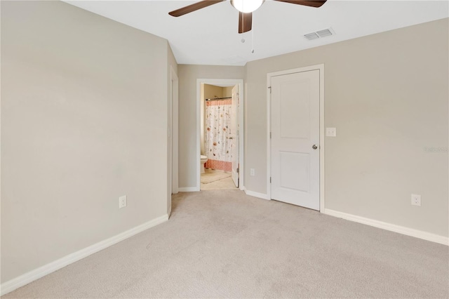 unfurnished bedroom featuring ensuite bathroom, ceiling fan, and light colored carpet