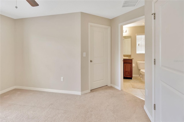 spare room with ceiling fan and light colored carpet