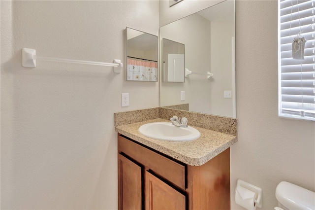 bathroom featuring vanity and toilet