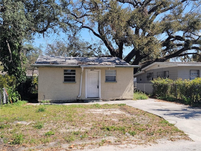 view of outdoor structure with concrete driveway and fence