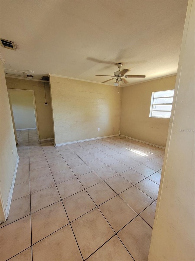 empty room featuring light tile patterned floors, baseboards, visible vents, and a ceiling fan