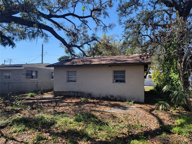 view of side of home featuring fence and stucco siding