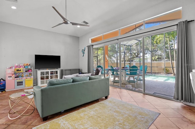 living room featuring ceiling fan, visible vents, a wealth of natural light, and tile patterned floors