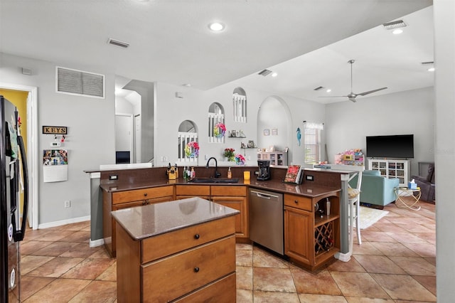 kitchen with visible vents, a sink, refrigerator with ice dispenser, an island with sink, and dishwasher