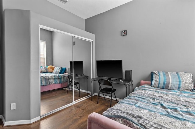 bedroom with a closet, wood finished floors, and baseboards