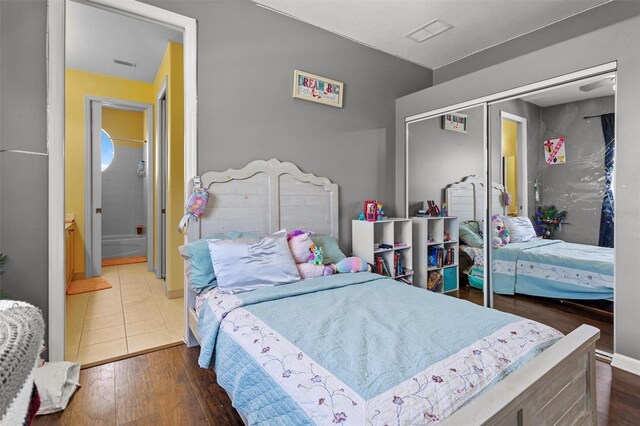 bedroom with a closet, visible vents, and wood finished floors