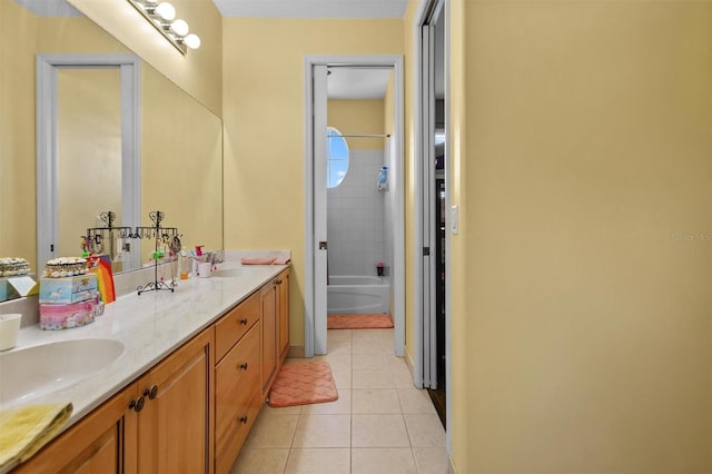 bathroom featuring shower / washtub combination, double vanity, a sink, and tile patterned floors