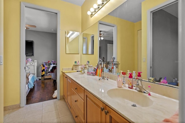 bathroom with double vanity, ensuite bath, ceiling fan, tile patterned floors, and a sink