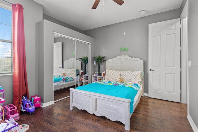 bedroom featuring ceiling fan, a closet, wood finished floors, and baseboards