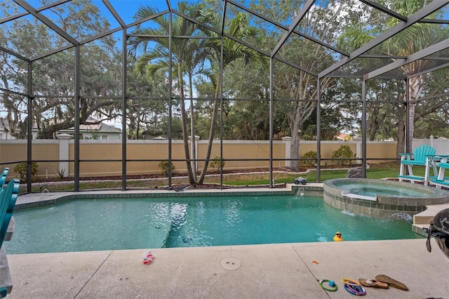 view of pool featuring glass enclosure, a fenced backyard, and a pool with connected hot tub