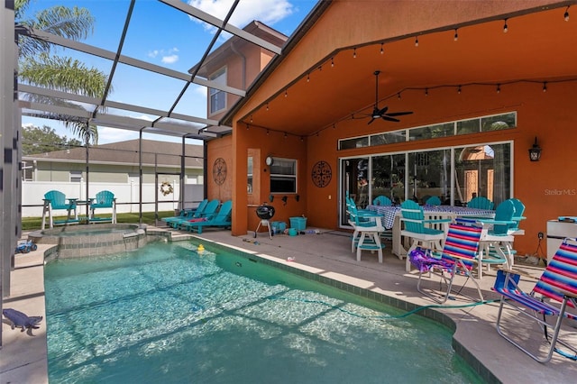 view of pool featuring ceiling fan, a patio, glass enclosure, fence, and a pool with connected hot tub