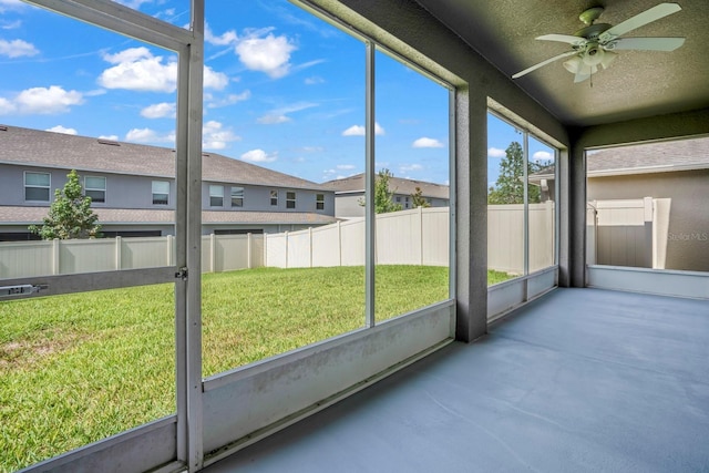 unfurnished sunroom with ceiling fan