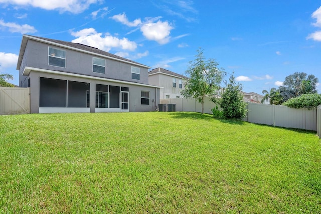 back of house featuring a yard and a sunroom