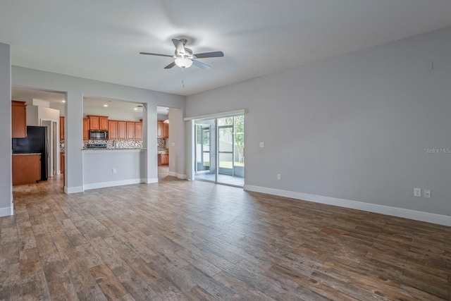 unfurnished living room with hardwood / wood-style floors and ceiling fan