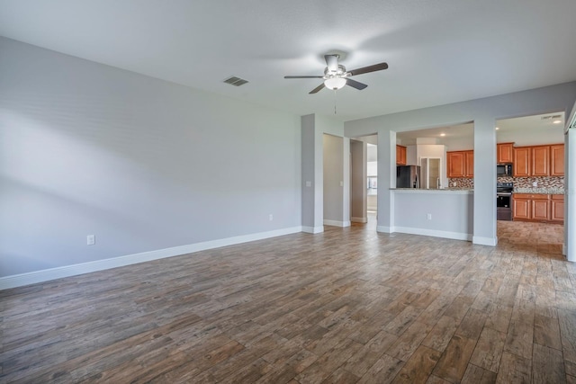 unfurnished living room featuring ceiling fan and hardwood / wood-style floors