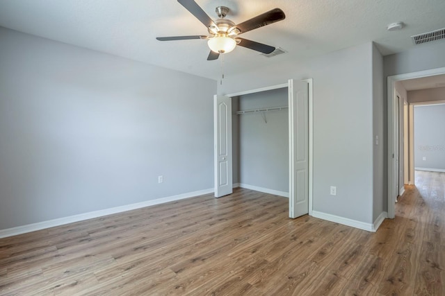 unfurnished bedroom featuring ceiling fan, a closet, and light hardwood / wood-style flooring