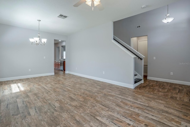 unfurnished living room with hardwood / wood-style flooring and ceiling fan with notable chandelier