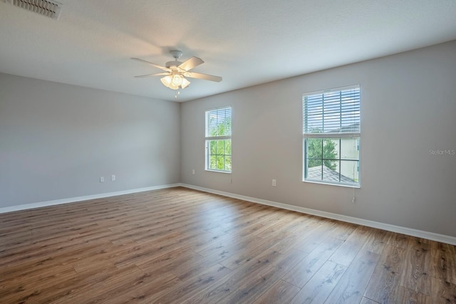 empty room with hardwood / wood-style flooring and ceiling fan