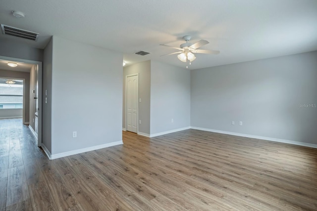 empty room with hardwood / wood-style flooring and ceiling fan