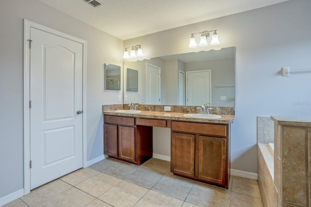 bathroom with vanity, tiled tub, tile patterned floors, and a textured ceiling