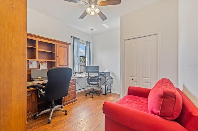 home office with light wood-type flooring and ceiling fan