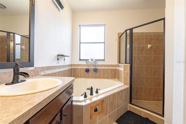 bathroom with vanity and shower with separate bathtub