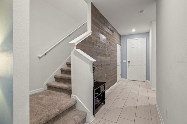 entrance foyer featuring wood walls and light tile patterned floors