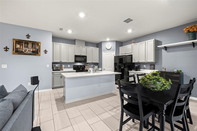 kitchen featuring black appliances, a center island with sink, white cabinetry, and sink