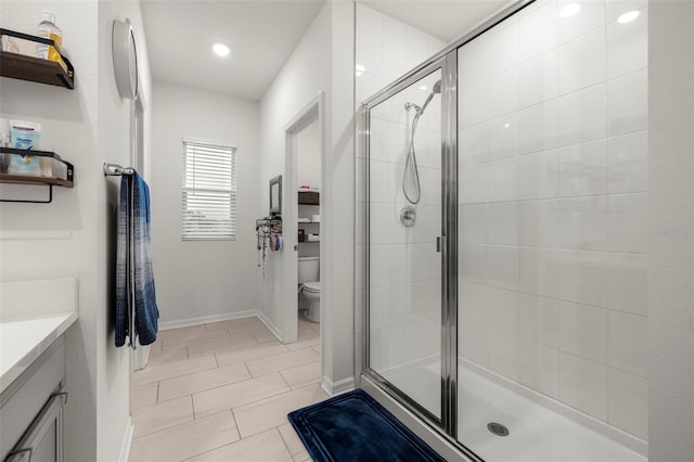 bathroom with walk in shower, vanity, and toilet