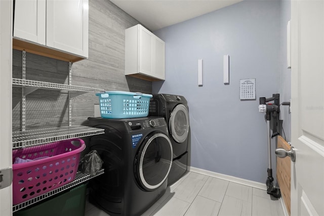 washroom featuring washer and dryer and cabinets