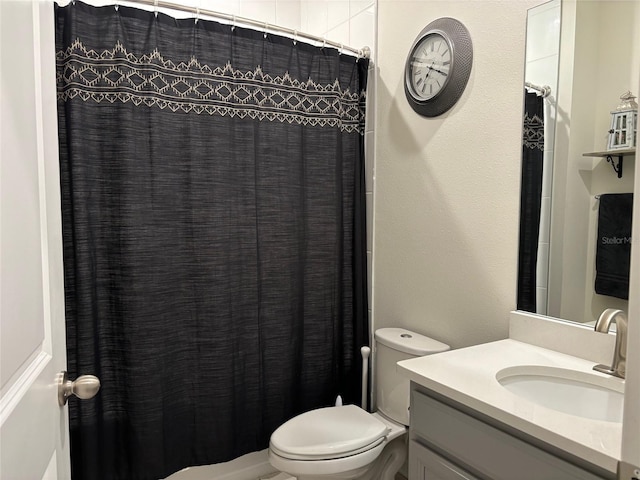 bathroom featuring vanity, toilet, and curtained shower