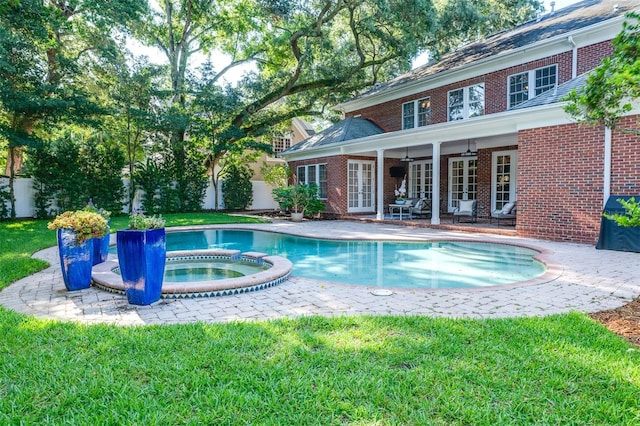 view of pool with a lawn, an in ground hot tub, and a patio