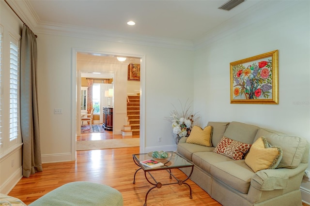 living room with light hardwood / wood-style floors and crown molding