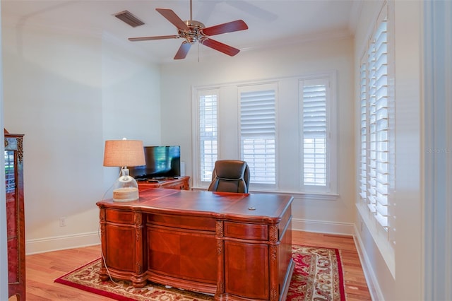 office space featuring light hardwood / wood-style floors, crown molding, ceiling fan, and a healthy amount of sunlight